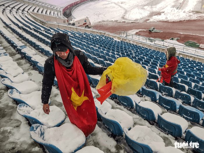 Cổ động viên Việt Nam nhặt rác giữa mưa tuyết sau trận chung kết - Ảnh 1.