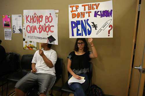 People hold up signs during a public forum held by the family of Tommy Le, a 20-year-old high school student who was shot and killed by King County sheriffs deputies in June, Wednesday, July 19, 2017 at the Asian Counseling and Referral Service.