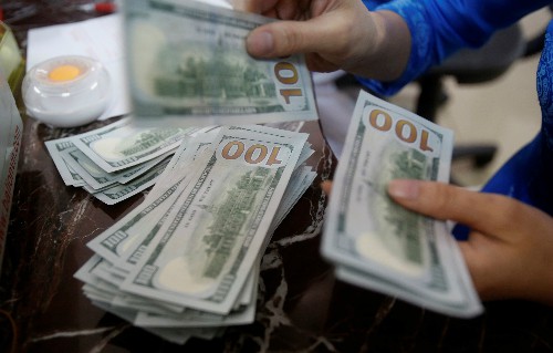 Một nhân viên ngân hàng đếm tiền USD tại Hà Nội. Ảnh: Reuters