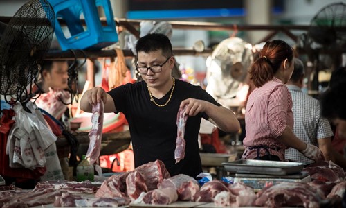 Một người bán thịt lợn tại chợ ở Chu Gia Giác. Ảnh: Washington Post.