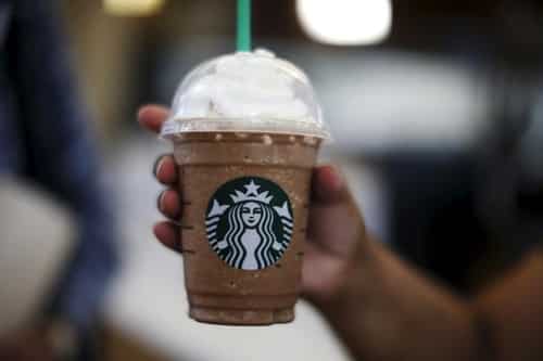 Khách hàng dùng cà phê của Starbucks trong một sân bay ở California (Mỹ). Ảnh: Reuters