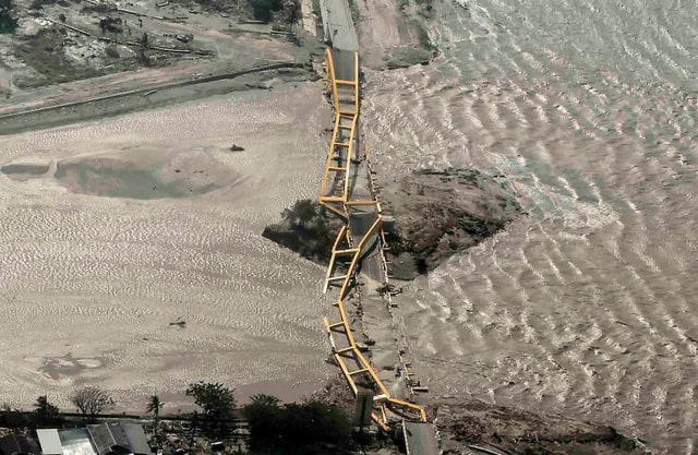 Một cây cầu bị sóng thần cuốn phăng (Ảnh: Reuters)