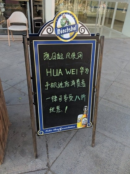 Biển báo ưu đãi cho khách dùng Huawei đặt trước cửa quán bar ở Bắc Kinh. Ảnh: @luoshanji/Twitter.