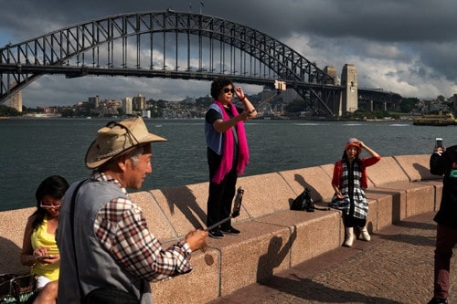 Một nhóm du khách Trung Quốc chụp ảnh tại cầu Harbour gần Nhà hát Opera Sydney hồi tháng 1. Ảnh: NYT. 