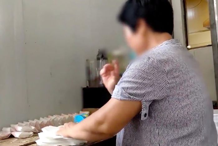 Người phụ nữ này liếm ngón tay sau khi gói bánh.