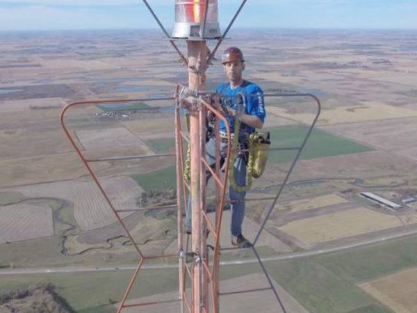 Kevin Schmidt đang leo lên ngọn tháp ăng ten truyền hình có độ cao 538m để thay bóng đèn. Ảnh Wholesomeposts.
