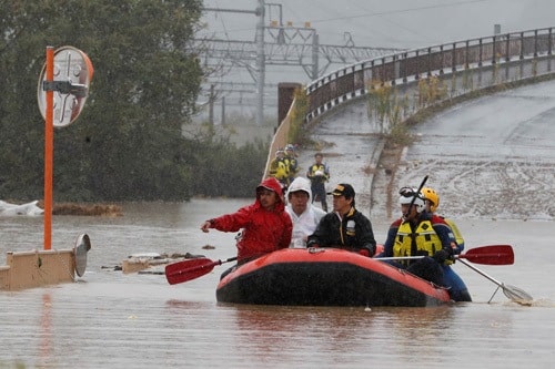 Lực lượng cứu hộ Nhật Bản sơ tán người dân bằng xuồng cao sau gần một tuyến đường bị ngập do sông tràn bờ ở tỉnh Nagano hôm nay. Ảnh: Reuters.