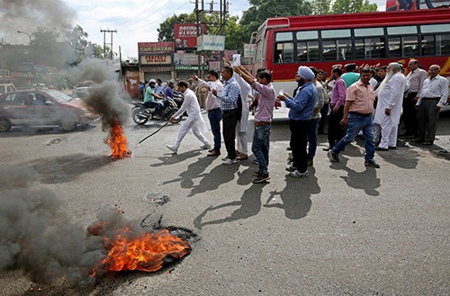 Những người ủng hộ các nghi phạm đốt lốp xe s during a protest Wednesday in Kathua, India, in support of an investigation into the rape and murder of an 8-year-old girl. (Mukesh Gupta/Reuters)
