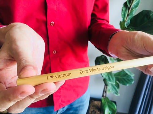 Michael Burdge giới thiệu chiếc ống hút làm bằng tre khắc dòng chữ Tôi yêu Việt Nam và Zero Waste Saigon. Ảnh: Hạnh Phạm.