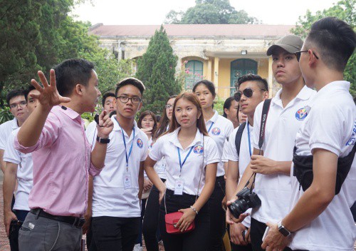 Hữu (phía tay phải Quỳnh) lắng nghe hướng dẫn viên khi thăm khu di tích Hoàng Thành Thăng Long. Ảnh: Trọng Giáp.