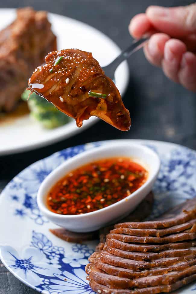  Bạn lấy nước sốt hầm trộn cùng hành lá và ớt tươi thái nhỏ để làm thành nước chấm ăn kèm.