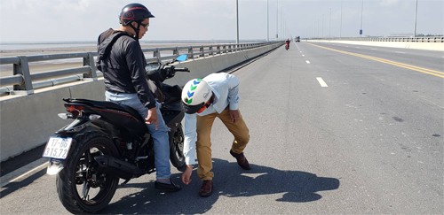 Một số người dân tham gia giao thông phát hiện đinh đã dừng xe nhặt nhưng không xuể. Ảnh: Giang Chinh