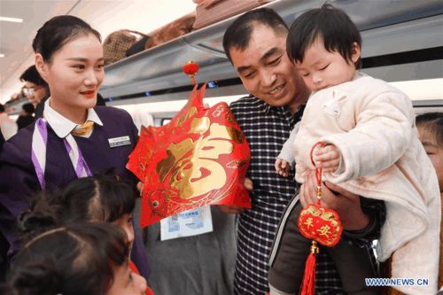Tiếp viên đường sắt Liu Lu tặng quà cho khách. Ảnh: Zhang Duan/Xinhua.