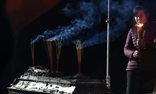 Ha Thi Thua đứng thắp hương trước quan tài của người chồng quá cố. Ảnh: AFP.