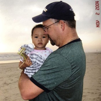 Ông Rob Shepherd bế Haven trên tại khi đứng trên bãi biển Đà Nẵng năm 2004. Ảnh: BBC.