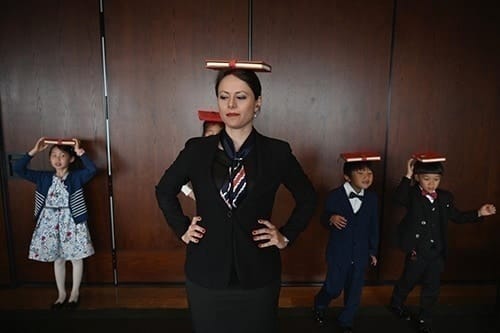 Danielle Liu (trái) và các học viên nhí được giáo viên hướng dẫn cách giữ thăng bằng sách trên đầu và bước đi. Ảnh: AFP