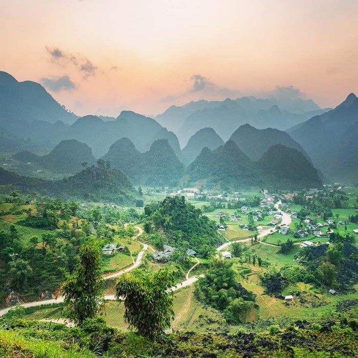 Đằng xa, lớp sương mờ che phủ đang hòa trộn với màu sắc cam nhạt của bình minh sắp hé.