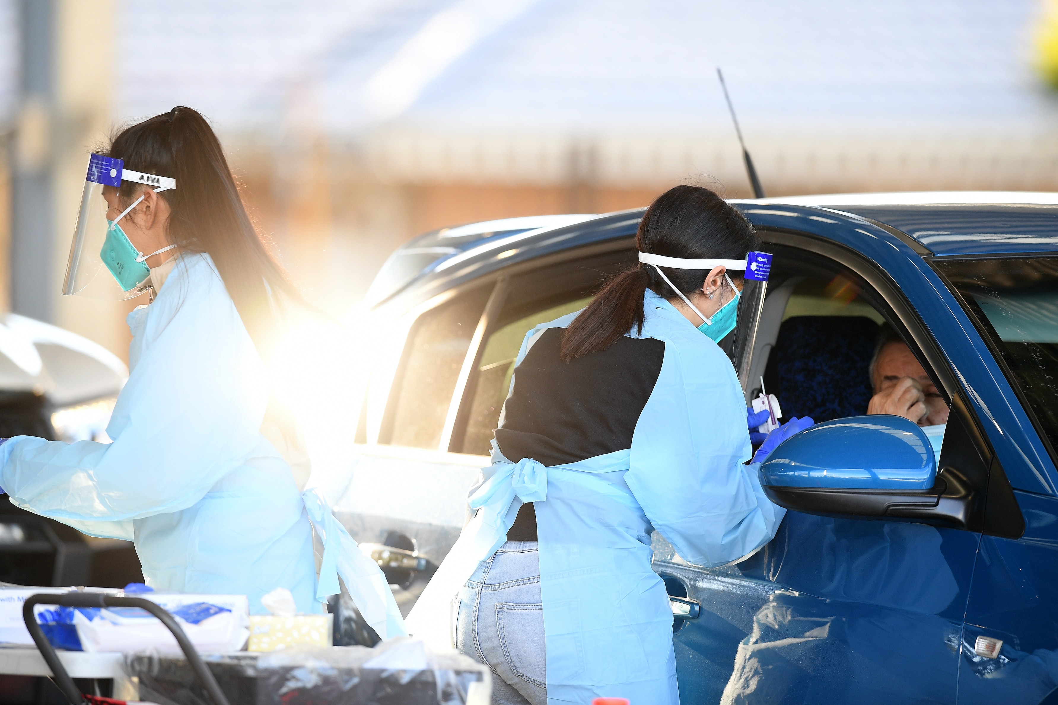 Health workers administer COVID-19 tests at a drive-through testing clinic at Fairfield Showground in Sydney on Friday, 16 July, 2021. 