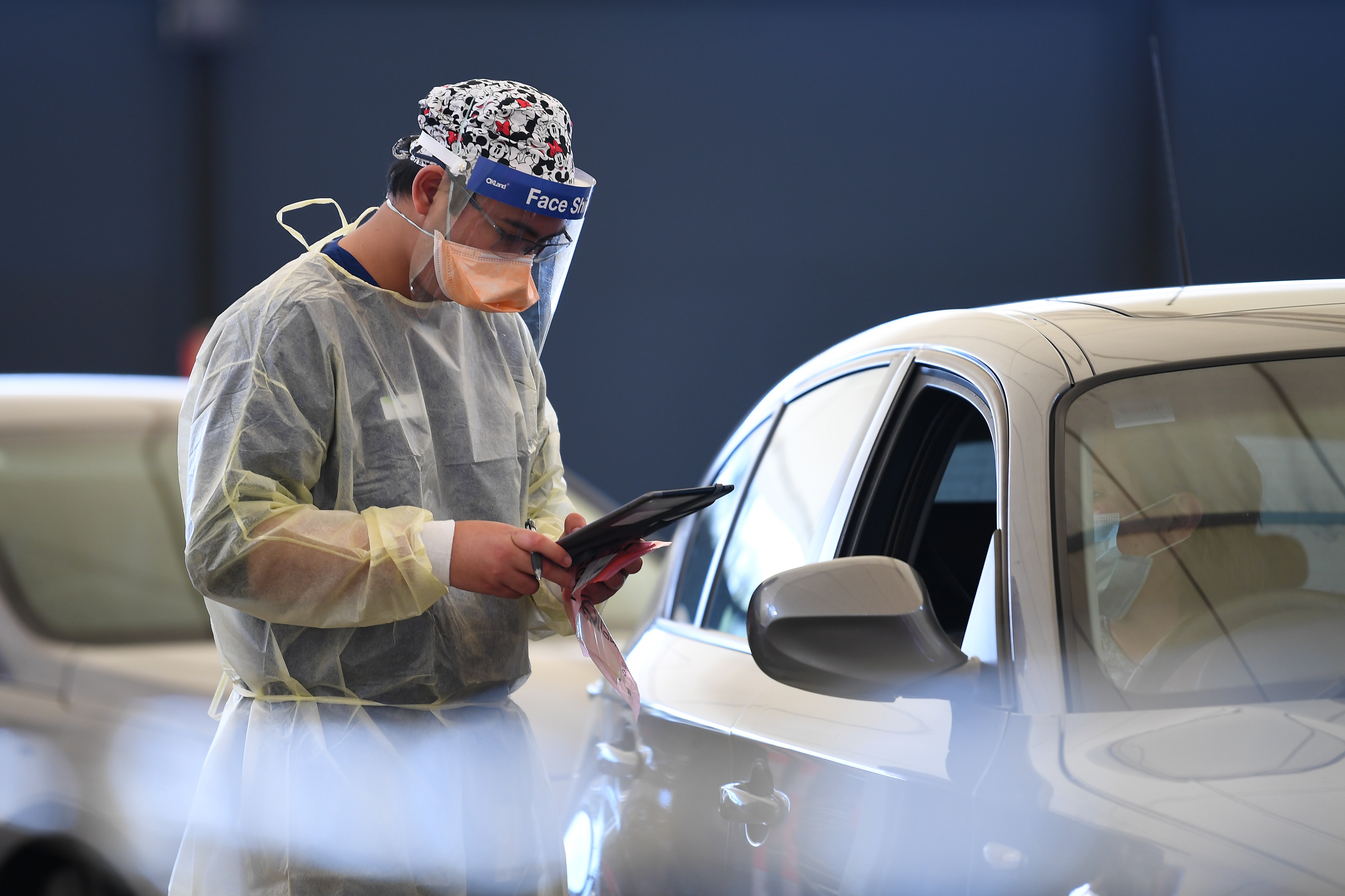Helathcare worker Allen Pelisco is seen working at a drive-through Covid19 testing facility in Melbourne