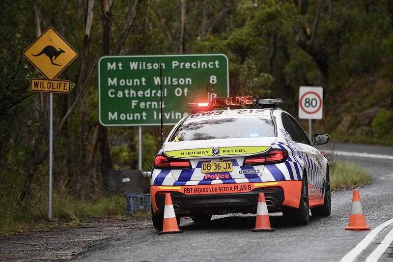 A police roadblock is set up at the entrance of the suburb of Mount Wilson, north of Katoomba, NSW, Tuesday, 18 January, 2022. 
